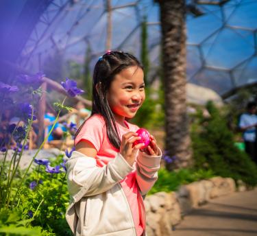 Girl holding a wooden painted Easter egg